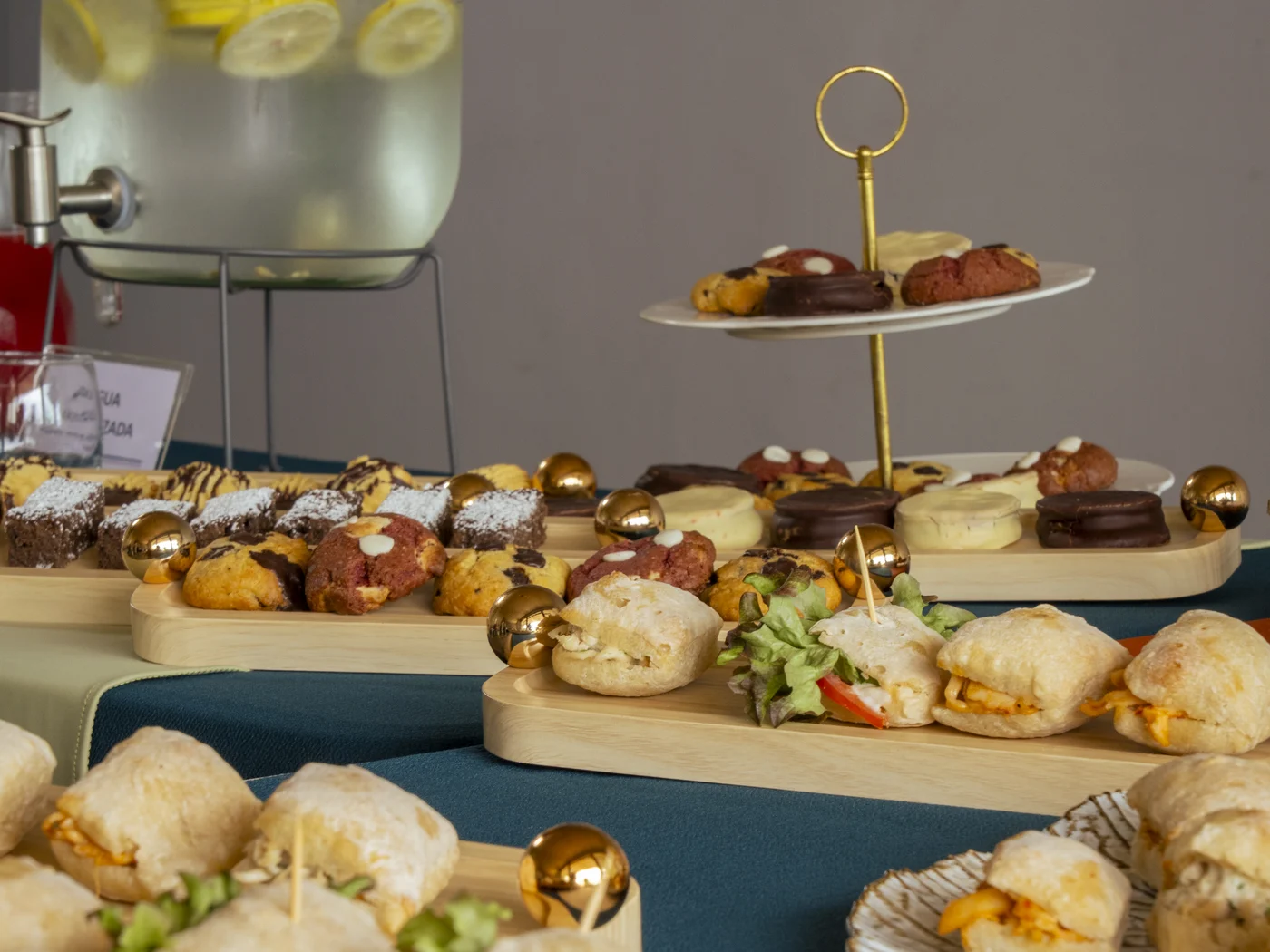 La mesa de banquetería de Gustito de cerca: agua saborizada, torre de dulces y bandejas