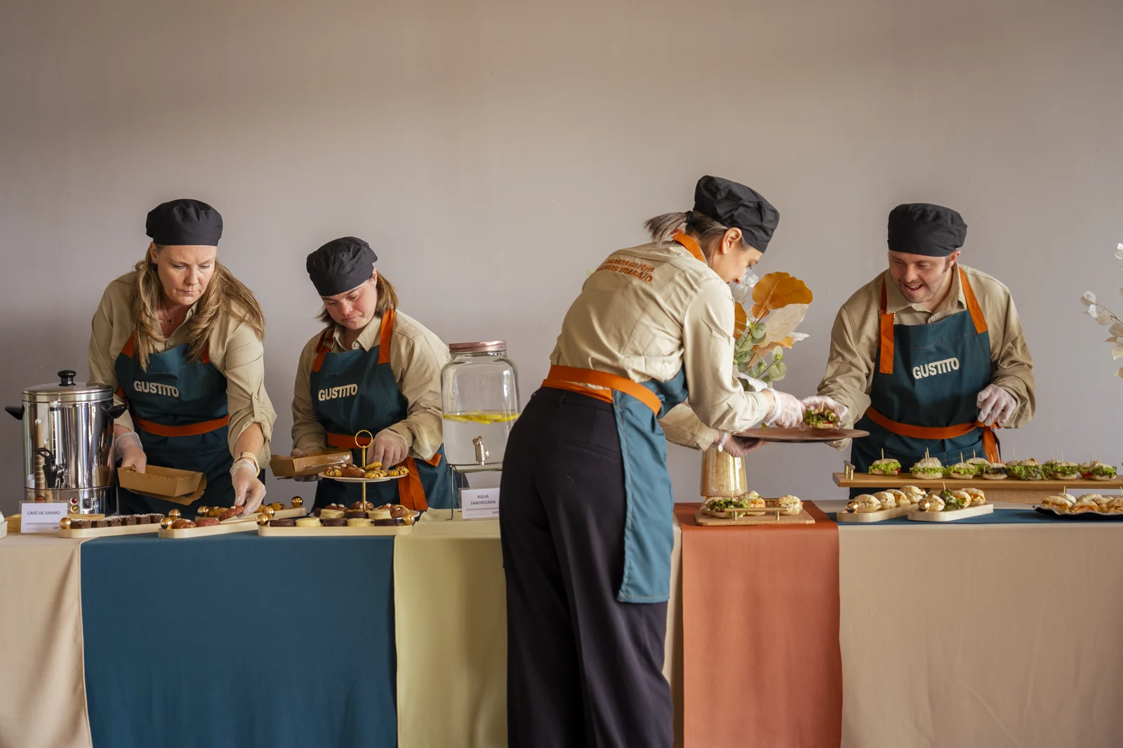 Los cuatro montando la mesa, cada uno en su puesto