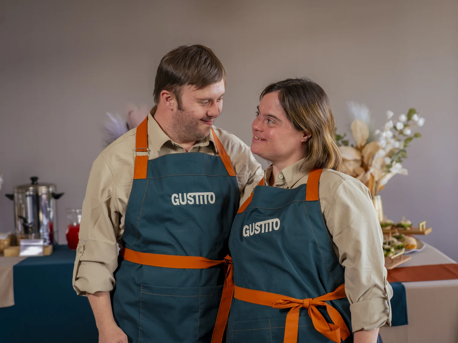 Daniel y Camila mirándose con sus delantales de Gustito: matrimonio y primer equipo de la empresa